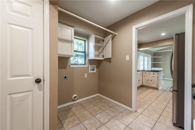 laundry room with light tile patterned floors, washer hookup, electric dryer hookup, and cabinets