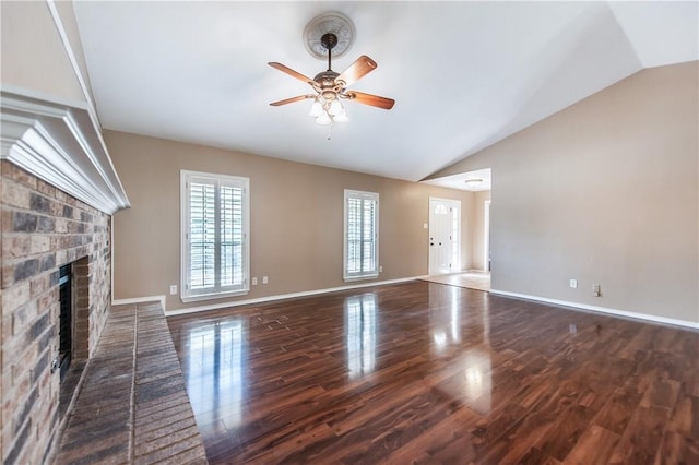 unfurnished living room with a brick fireplace, dark hardwood / wood-style flooring, lofted ceiling, and ceiling fan