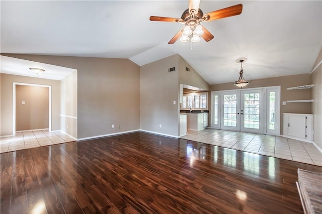 unfurnished living room with ceiling fan, french doors, vaulted ceiling, and light hardwood / wood-style floors