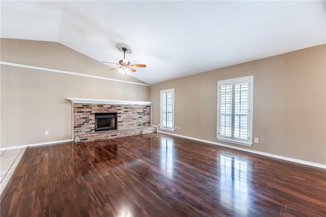 unfurnished living room featuring lofted ceiling, ceiling fan, a fireplace, and hardwood / wood-style floors