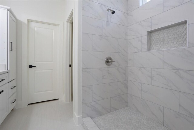 bathroom featuring vanity and tiled shower