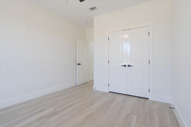 unfurnished bedroom with ceiling fan, a closet, and light hardwood / wood-style flooring