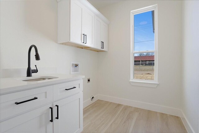 laundry room with light hardwood / wood-style floors, sink, hookup for a washing machine, hookup for an electric dryer, and cabinets