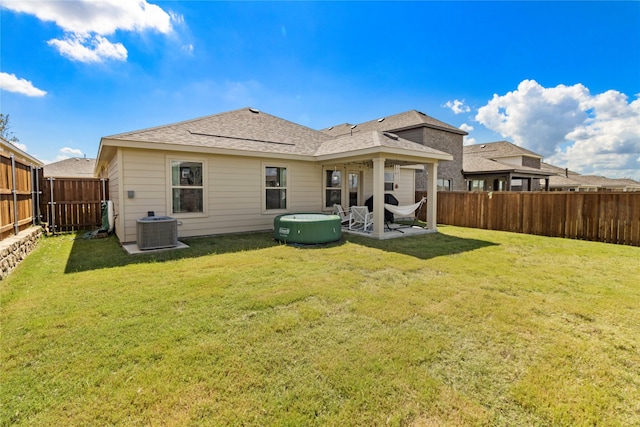 rear view of house with central AC unit, a yard, and a patio