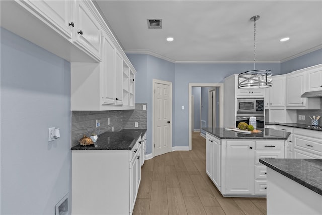 kitchen featuring pendant lighting, backsplash, white cabinetry, and stainless steel appliances