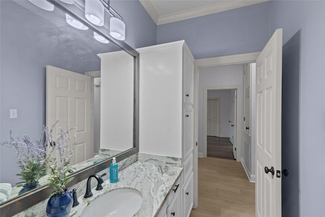 bathroom featuring vanity, crown molding, and hardwood / wood-style flooring