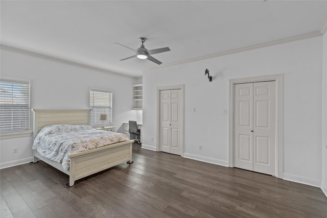 bedroom with ceiling fan, crown molding, dark hardwood / wood-style floors, and multiple closets