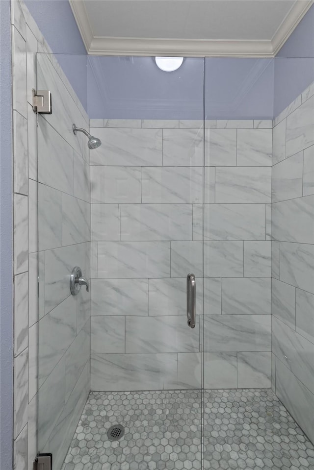 bathroom featuring a shower with door and crown molding