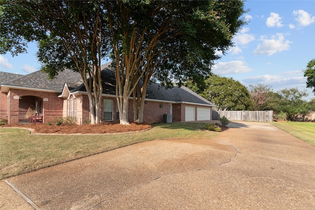 view of side of property featuring a garage, a lawn, and central air condition unit