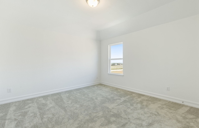 unfurnished room featuring light carpet and baseboards