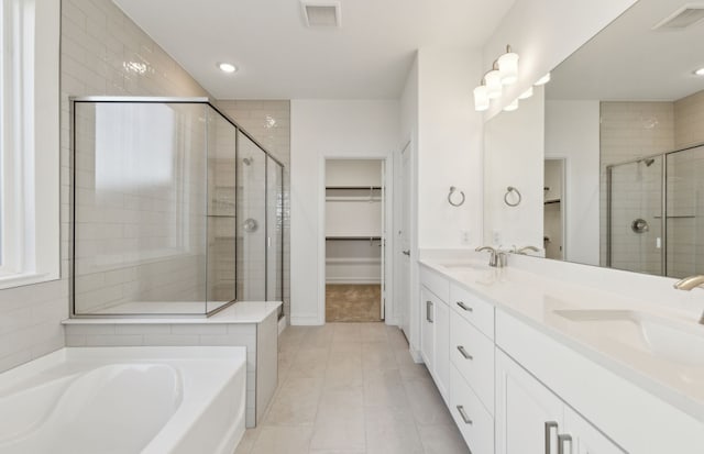 bathroom with a sink, visible vents, and a walk in closet