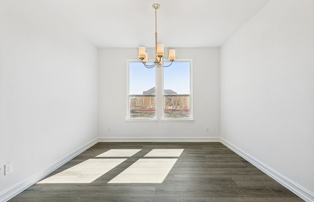 unfurnished dining area with a notable chandelier, baseboards, and dark wood-type flooring