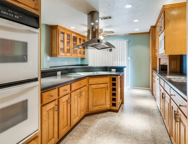 kitchen with a ceiling fan, white appliances, visible vents, island range hood, and dark countertops