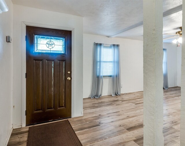 foyer with a ceiling fan and light wood-style floors