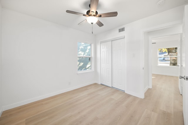 unfurnished bedroom with ceiling fan, a closet, and light hardwood / wood-style flooring