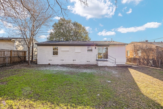 rear view of house featuring a yard