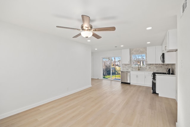 kitchen with white cabinetry, stainless steel appliances, tasteful backsplash, and sink