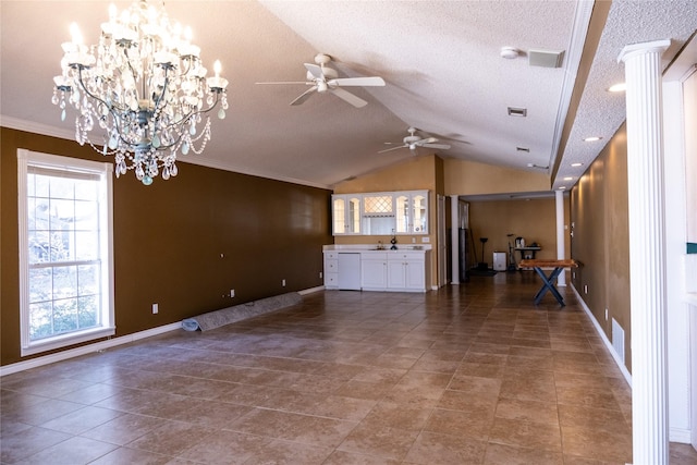 unfurnished living room featuring ceiling fan with notable chandelier, a textured ceiling, ornamental molding, and vaulted ceiling