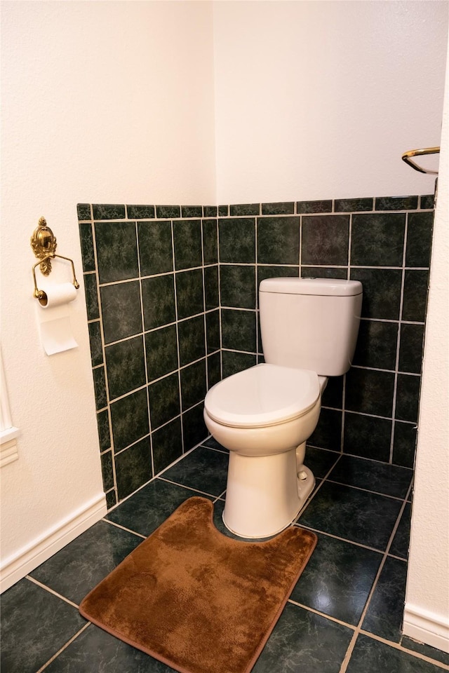 bathroom with tile walls, tile patterned floors, and toilet