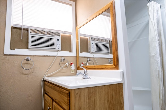 bathroom featuring a shower with shower curtain, cooling unit, and vanity