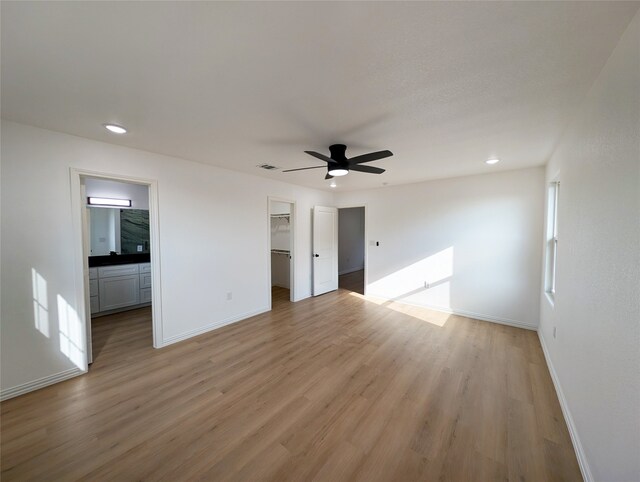 kitchen with light hardwood / wood-style floors, sink, white cabinetry, light stone countertops, and appliances with stainless steel finishes