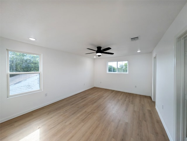 unfurnished room with baseboards, a ceiling fan, visible vents, and light wood-style floors