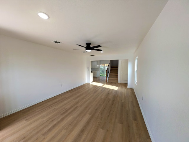 interior space with visible vents, stairway, baseboards, and wood finished floors