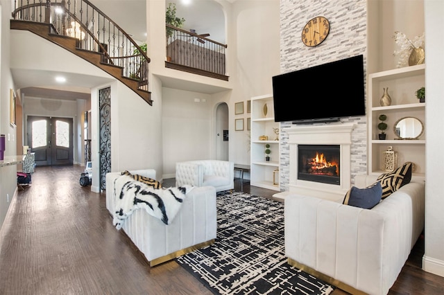 living room with built in shelves, dark hardwood / wood-style floors, french doors, and a high ceiling