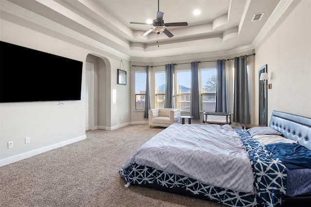 bedroom featuring a tray ceiling, ornamental molding, ceiling fan, and carpet