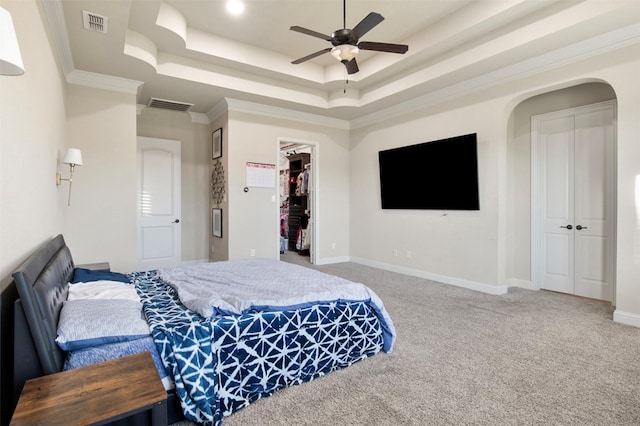 bedroom featuring a closet, carpet floors, a raised ceiling, and ceiling fan