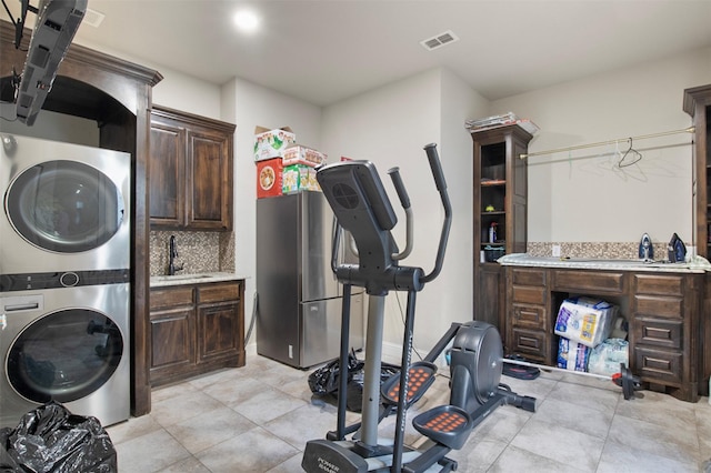 laundry area featuring stacked washer and dryer and sink