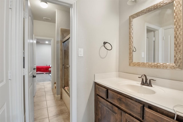 bathroom with enclosed tub / shower combo, vanity, and tile patterned floors