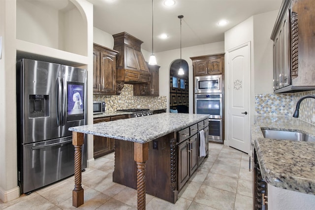 kitchen with tasteful backsplash, stainless steel appliances, sink, and a kitchen island