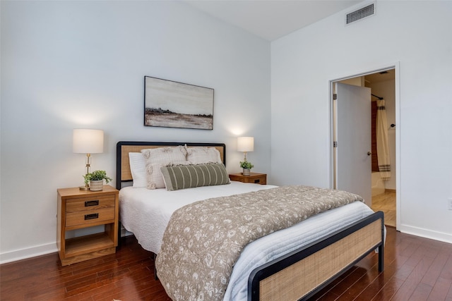 bedroom featuring connected bathroom and dark hardwood / wood-style flooring