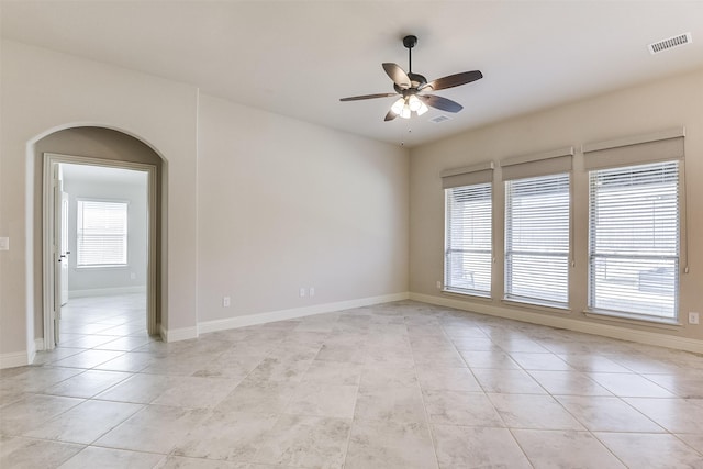 tiled spare room with ceiling fan