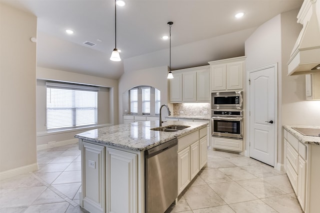 kitchen featuring pendant lighting, appliances with stainless steel finishes, sink, a center island with sink, and custom range hood