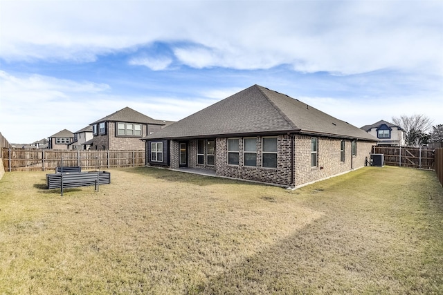 back of house featuring central AC unit and a lawn