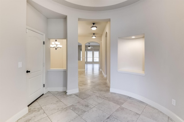 hall featuring light tile patterned floors and an inviting chandelier