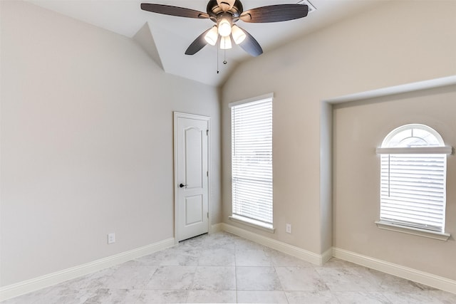 spare room with ceiling fan, light tile patterned floors, and vaulted ceiling