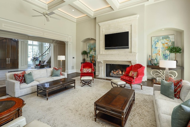 living room with ceiling fan, beam ceiling, coffered ceiling, hardwood / wood-style flooring, and ornamental molding