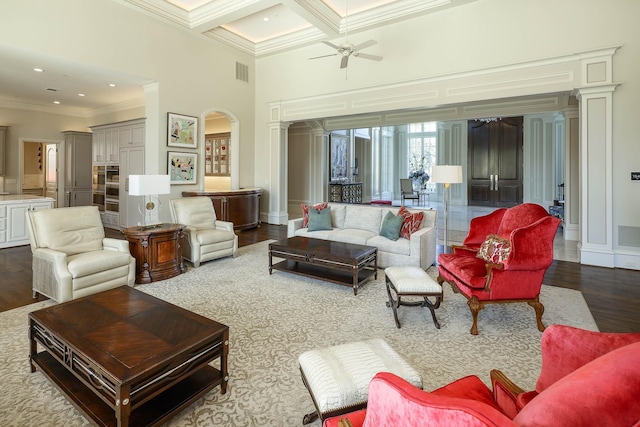 living room with coffered ceiling, ceiling fan, wood-type flooring, crown molding, and beamed ceiling