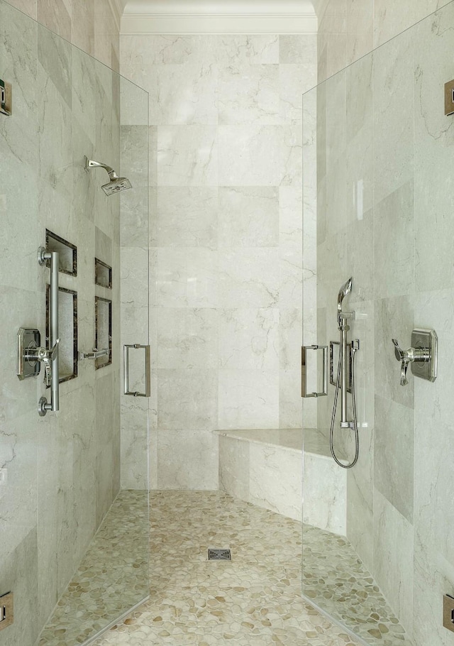 bathroom with a shower with door and ornamental molding