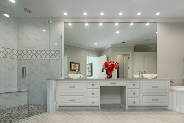 bathroom featuring a shower with door, vanity, and crown molding