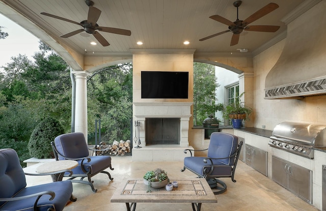 view of patio / terrace with an outdoor kitchen, a tiled fireplace, and grilling area