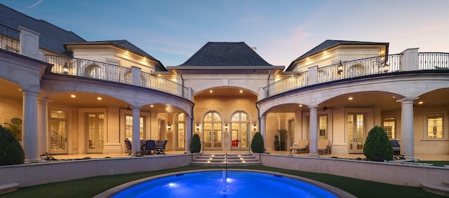 pool at dusk with french doors