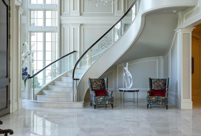 stairway featuring decorative columns and a high ceiling