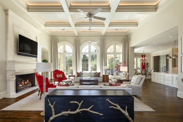 living room featuring coffered ceiling, ceiling fan, a high end fireplace, crown molding, and beamed ceiling