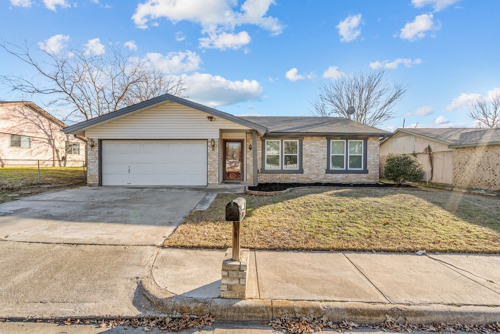 single story home featuring a garage and a front lawn