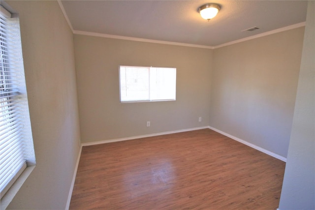 empty room featuring ornamental molding and hardwood / wood-style flooring