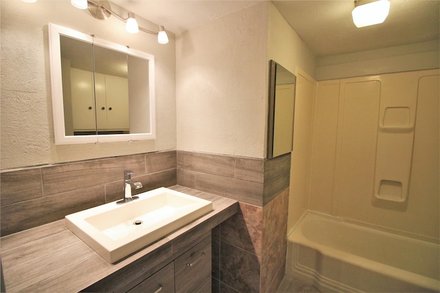 bathroom with vanity and tile walls